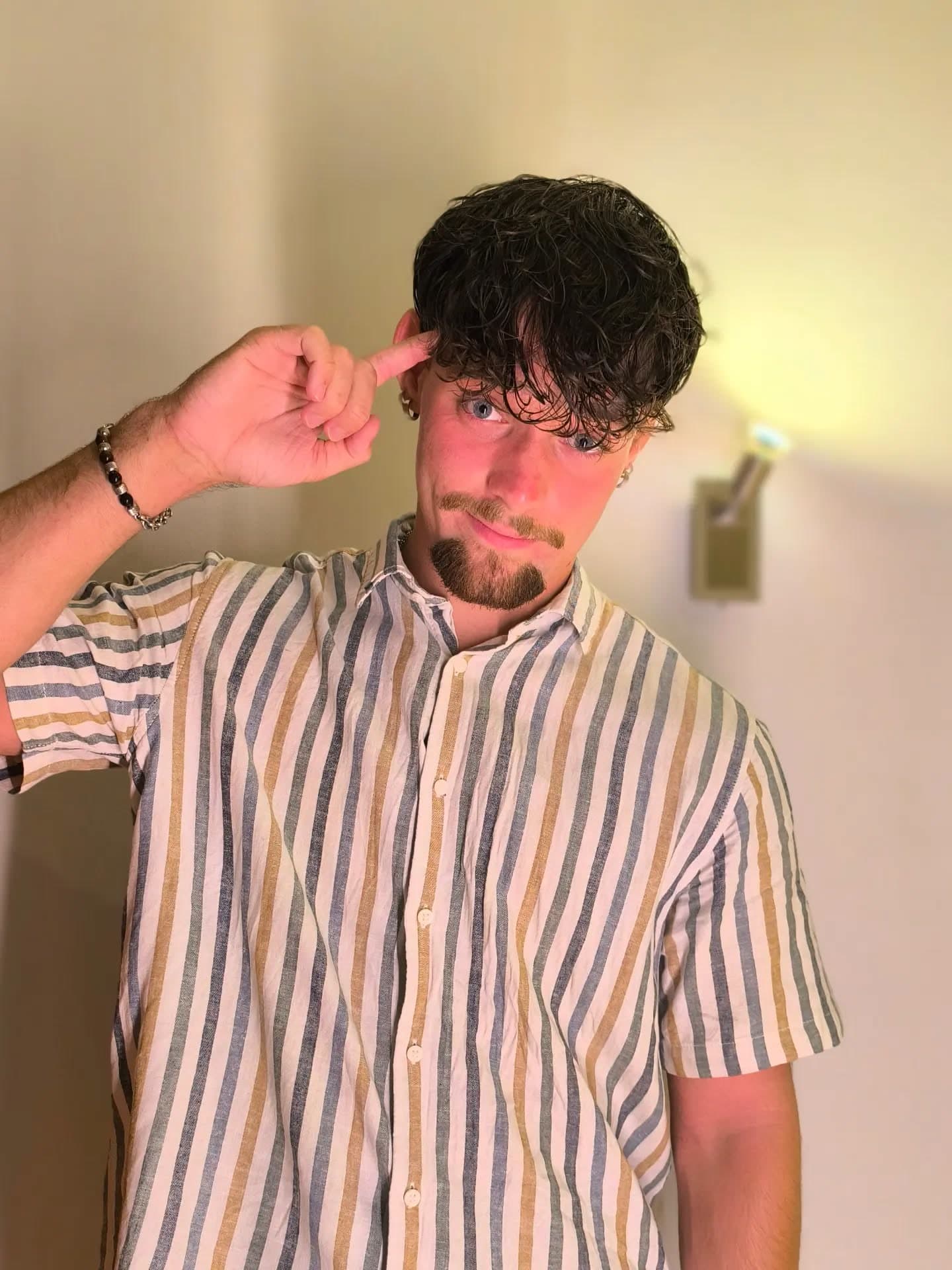 Maxi tippt sich mit dem Finger an die Schläfe und schaut in die Kamera